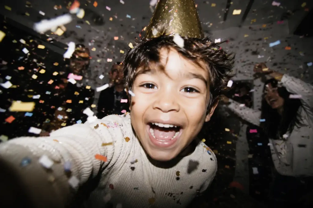 Kind mit Partyhut feiert Geburtstag zwischen Konfetti als emotionaler Moment für personalisierte Songs